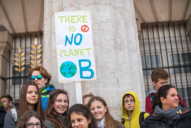 Image of young protesters holding a There is no Planet B sign